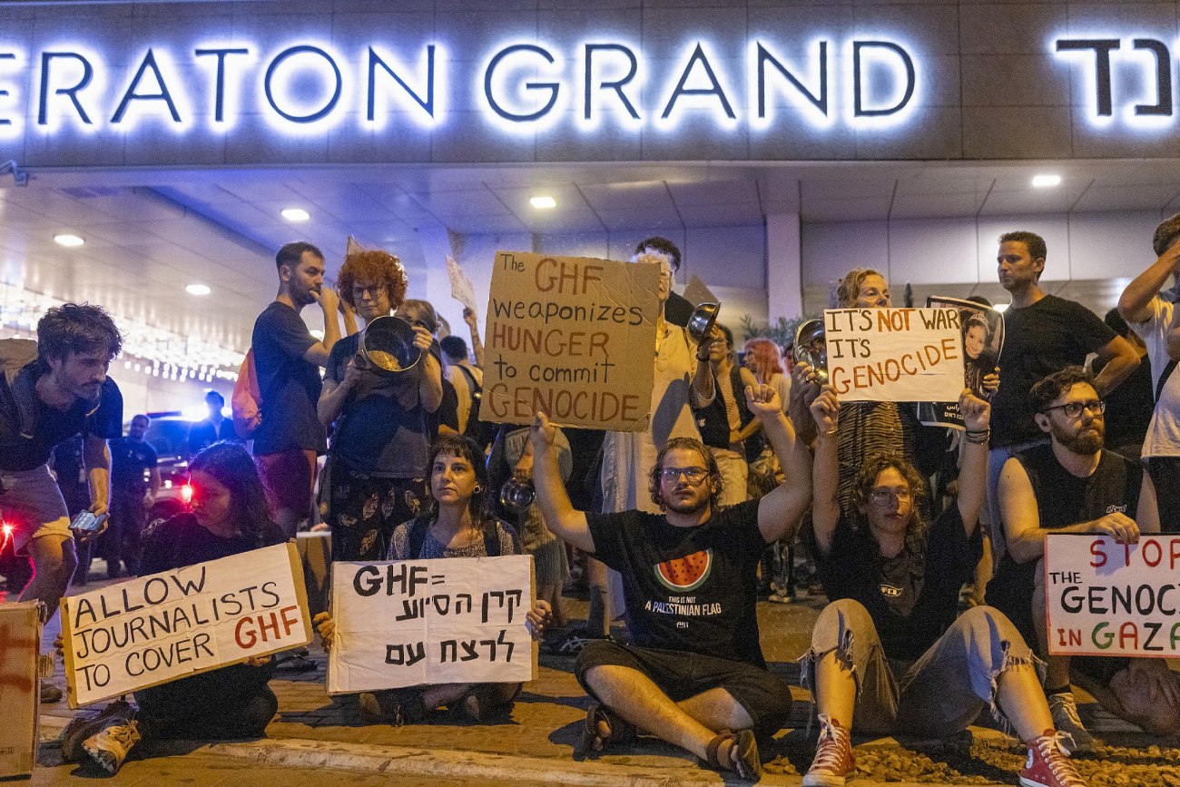 Manifestantes em Tel Aviv seguram cartazes denunciando a Fundação Humanitária de Gaza (GHF) por seu papel no genocídio e na fome em Gaza, em 13 de agosto de 2025. (Oren Ziv/Activestills)
