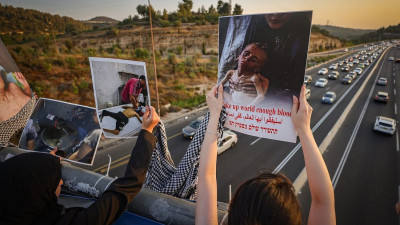 Israelitas protestam contra a guerra e a crise humanitária em Gaza, numa ponte rodoviária perto de Jerusalém, em 15 de agosto de 2025