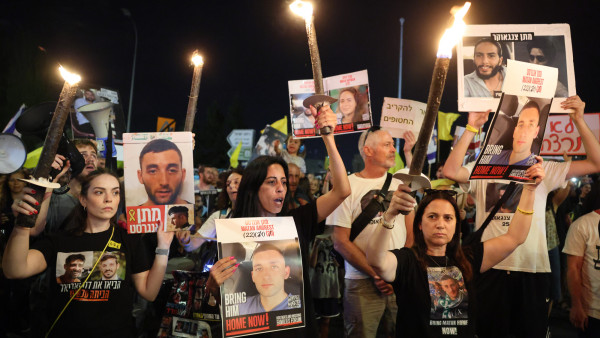 Familiares e amigos de reféns israelitas manifestam-se à porta da sede do governo durante a reunião do Conselho de Segurança.